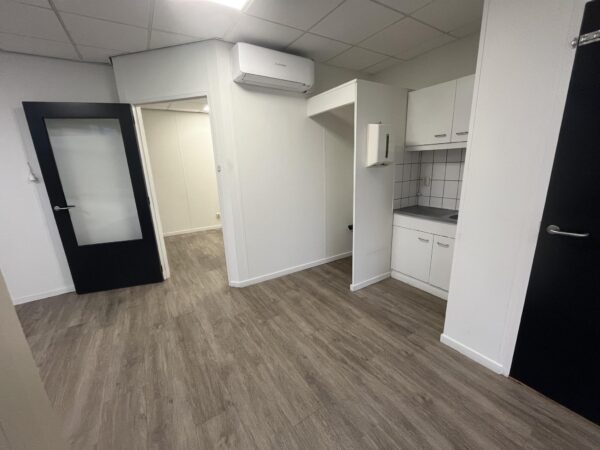 Kleine kitchenette met witte kasten in een kantoorruimte aan de Burgemeester Smitsstraat.